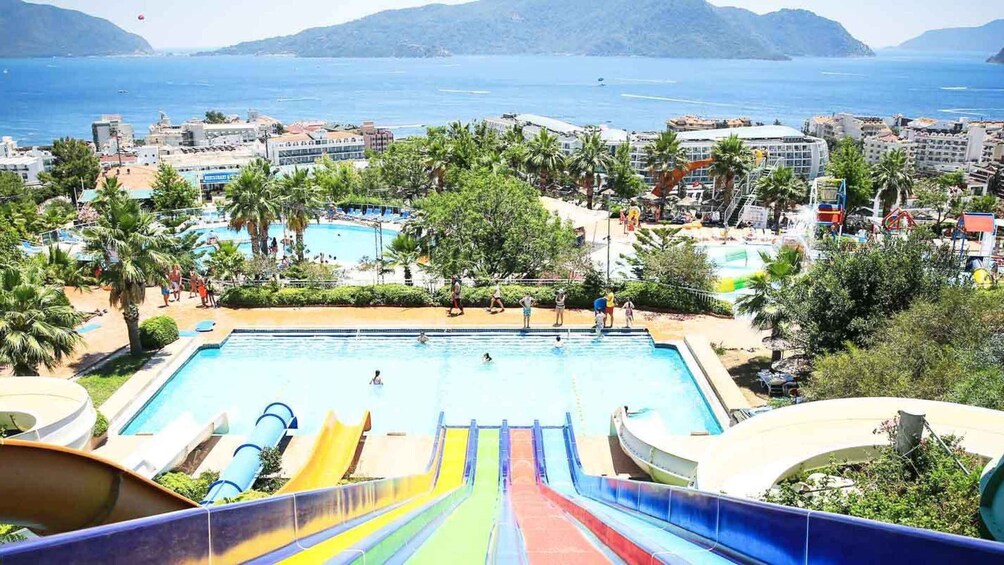 A water park with a large pool, slides, and palm trees. 3