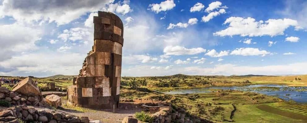 A stone structure in a rural landscape with a river and fields. 3