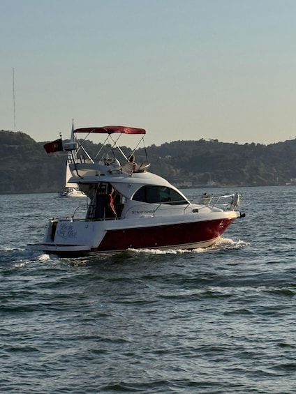 A red and white boat named 'Starfisher' on the water with a flag and a canopy. 3