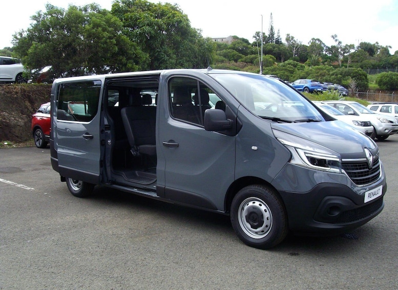 A gray Renault van parked in a lot with trees and other vehicles in the background. 3
