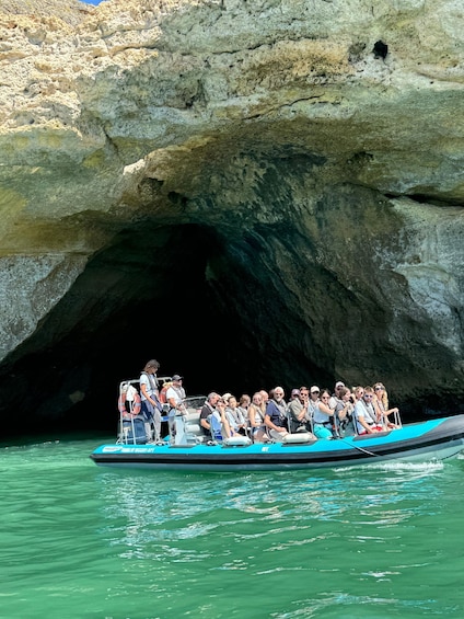 Une excursion en bateau avec des passagers devant une grande grotte. 5