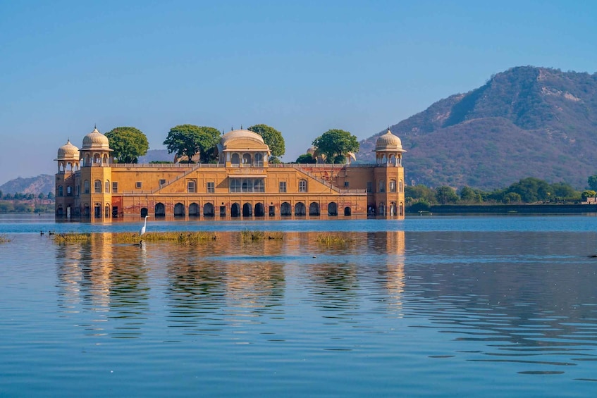 A historic building with domes and arches on a lake. 4