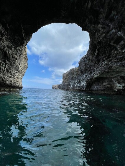 A natural rock arch over clear blue sea. 2