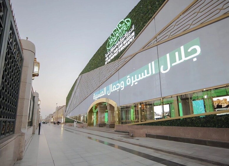 A modern building with a green sign reading 'The Emirates of the Future Museum of the Emirates Biography.' 1