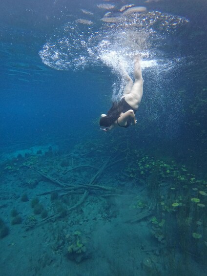 A person swimming underwater with bubbles rising to the surface. 2