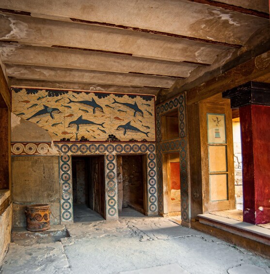 An ancient room with frescoes of marine life and geometric patterns on the walls. 5