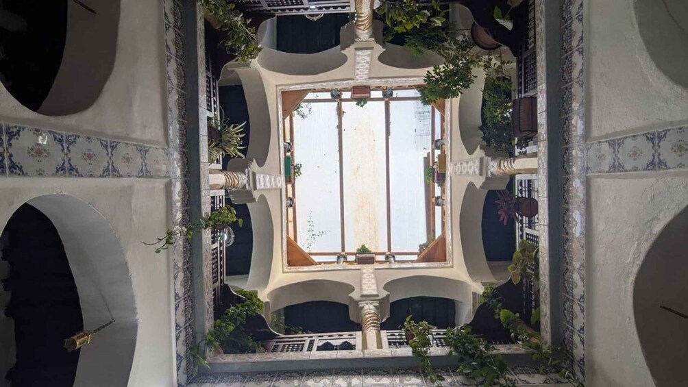 A courtyard with a central fountain, surrounded by arches and potted plants. 3