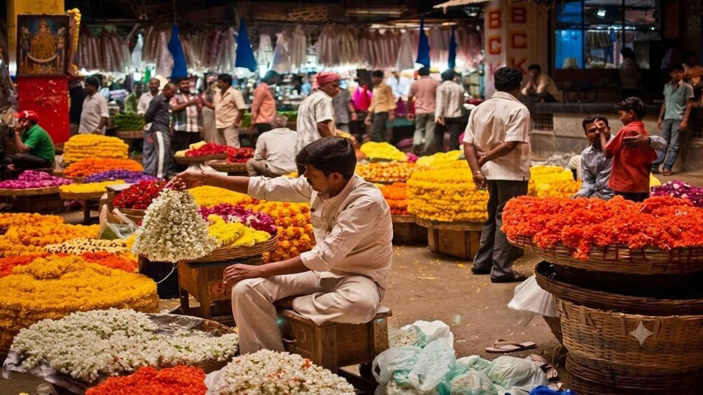 A flower market with a man arranging flowers. 1