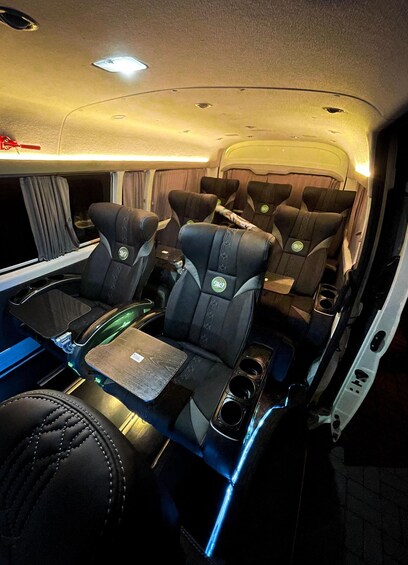 A luxurious interior with leather seats, a central table, and overhead lighting. 5