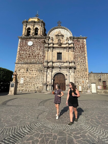 A historic stone church with a bell tower and a large arched doorway. 5