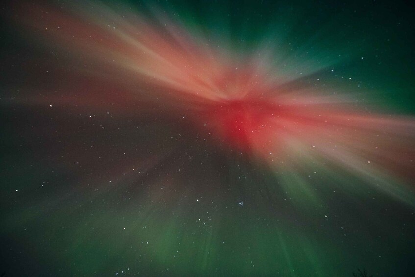 A starry night sky with a bright red and green light source. 2