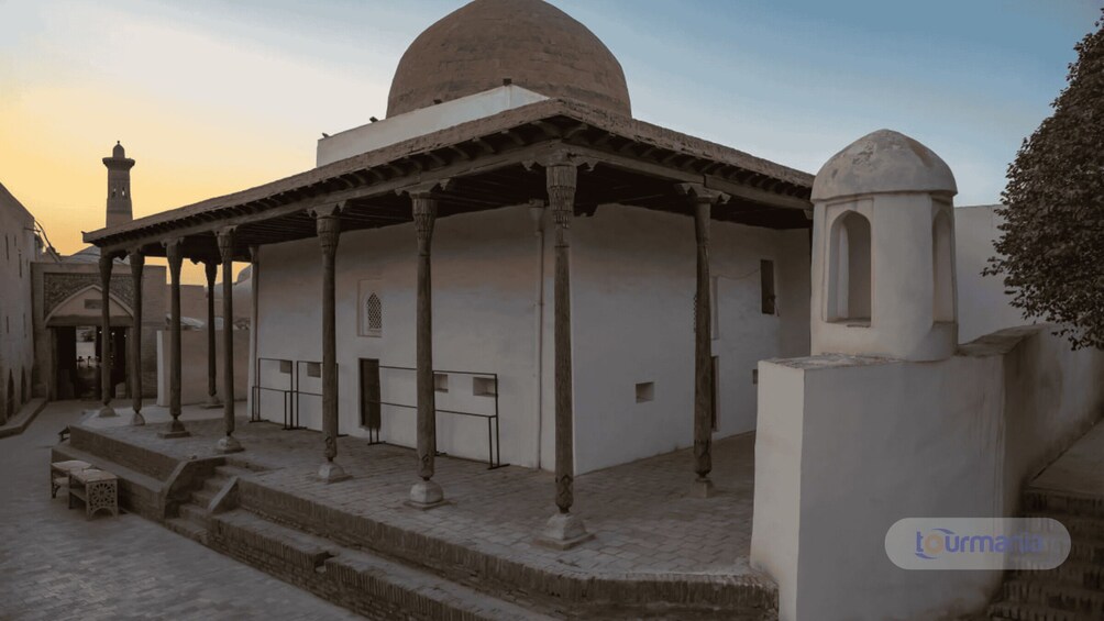 A historical building with a dome and a minaret, featuring a covered porch with columns. 2