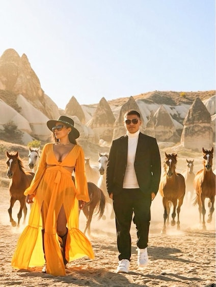 A desert landscape with horses and people. 5