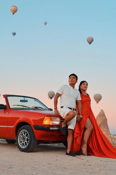 A red convertible car with a man and a woman standing beside it. 1
