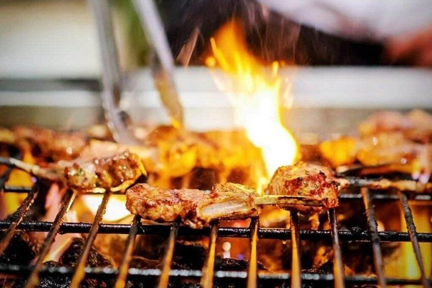 Grilled meat on a grill with visible flames. 2