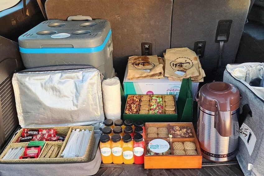 A car trunk filled with snacks, drinks, and a thermos. 4