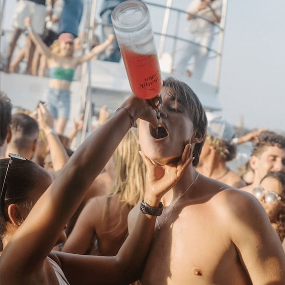 A person drinking from a glass with a red liquid. 3