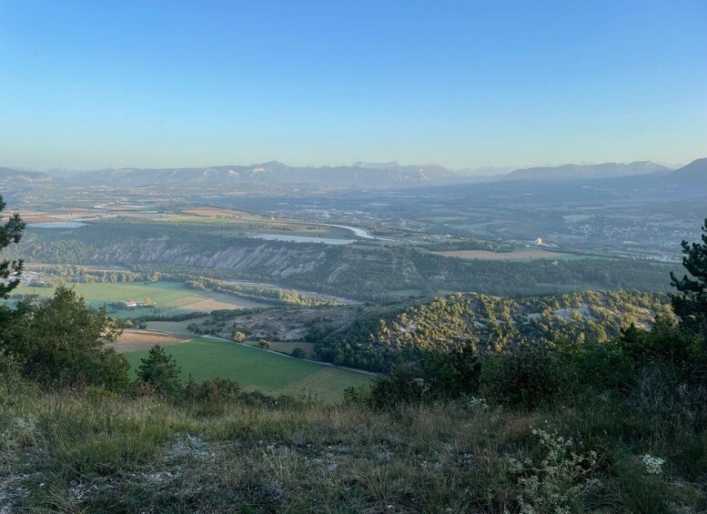 A mountainous landscape with a river, green fields, and distant mountains. 5