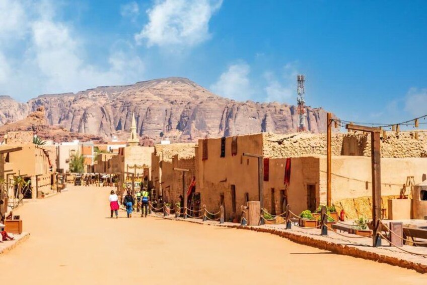 A desert town with buildings, a clear sky, and mountains in the background. 5
