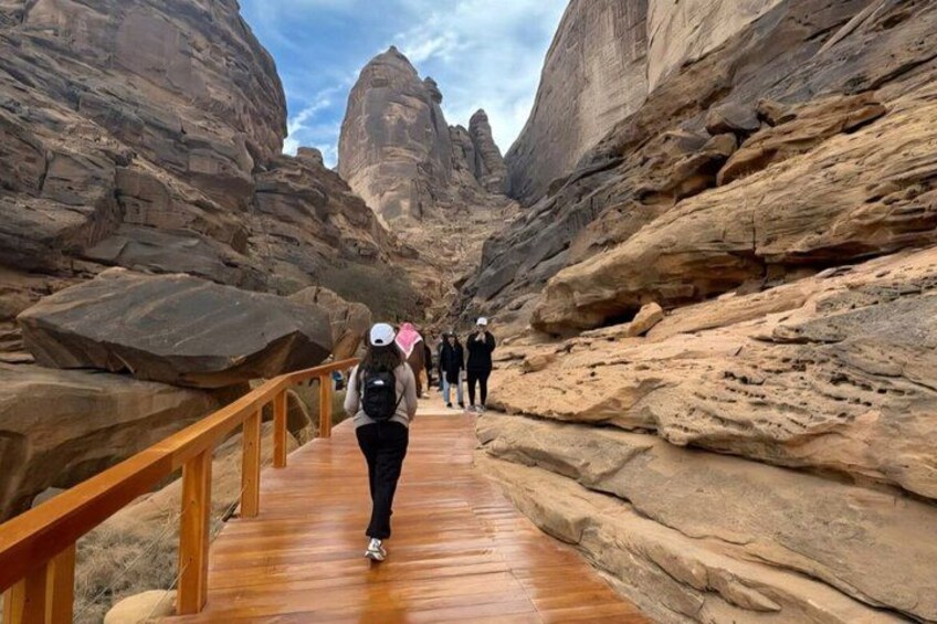 A wooden boardwalk in a canyon with rock formations. 2