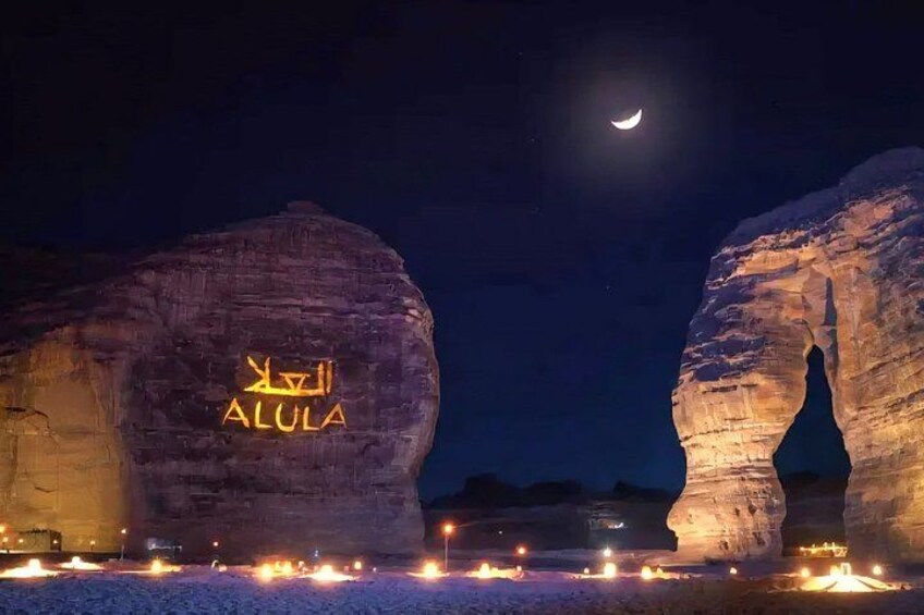 Illuminated rock formations with the text 'ALULA' and a crescent moon in the sky. 2