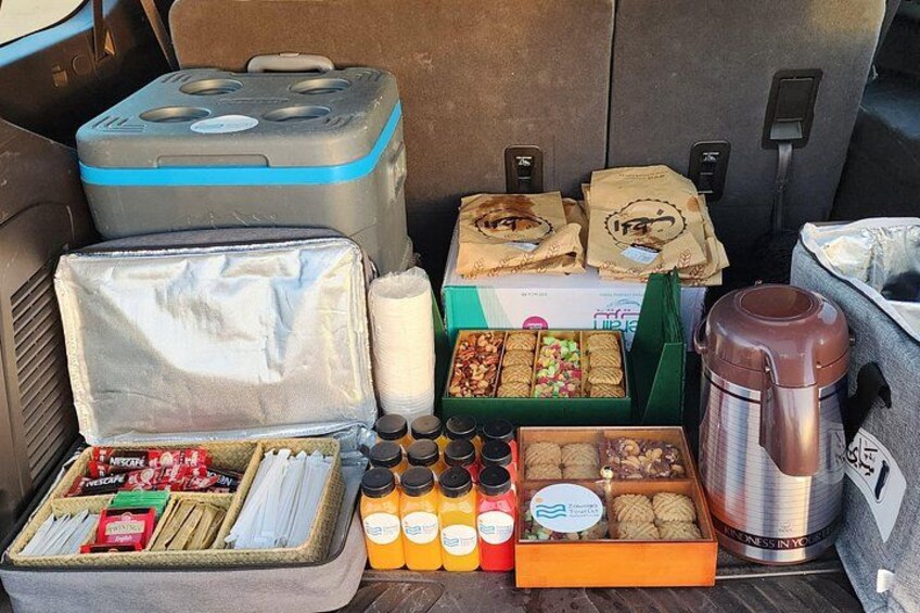 A variety of food items and beverages in a vehicle's trunk. 4