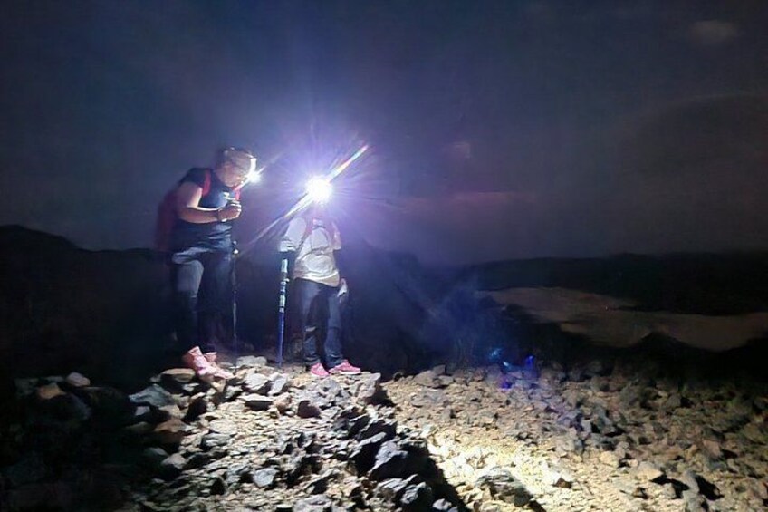 Two people hiking at night with flashlights. 2
