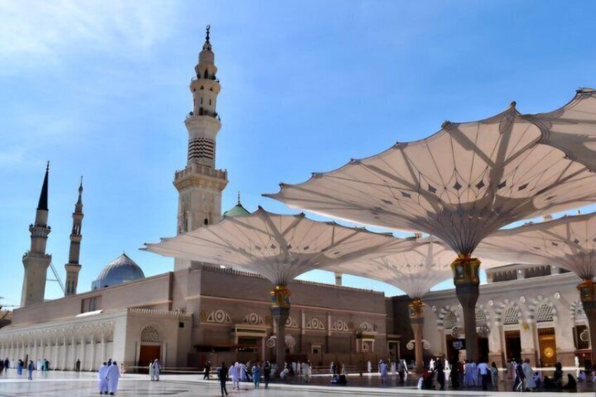 A mosque with minarets, a large dome, and shaded walkways. 4