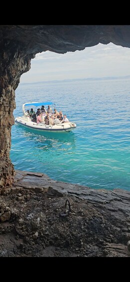 A boat with people on a rocky shoreline. 5