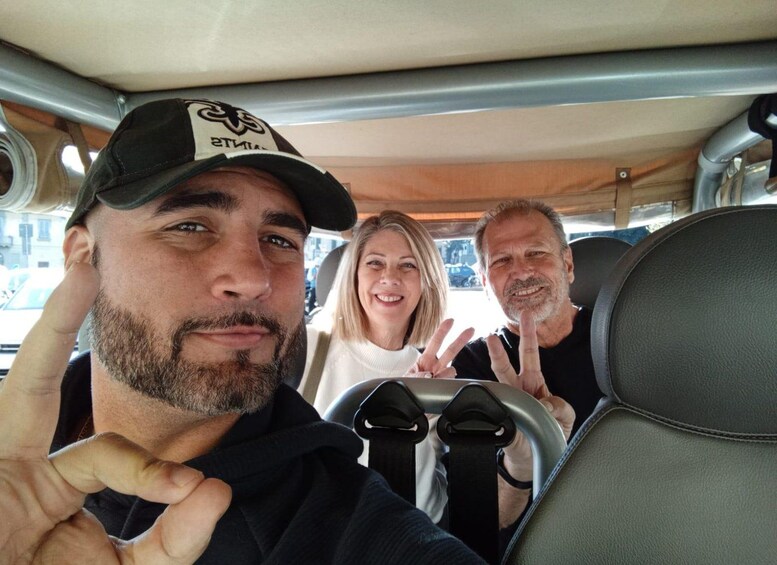 Three people in a vehicle with a steering wheel and seats. 4