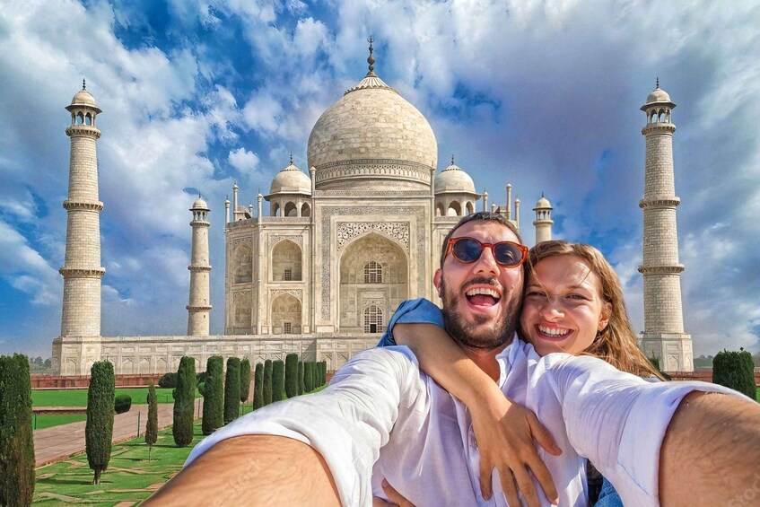 A couple taking a selfie with the Taj Mahal in the background. 1