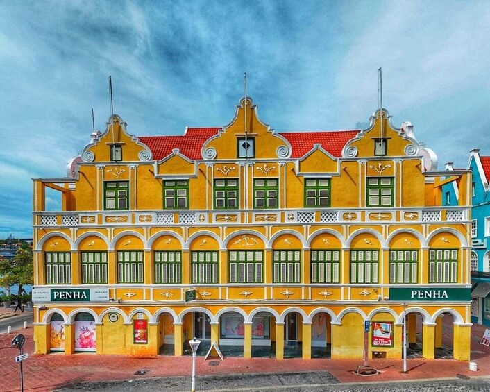 Keltainen rakennus, jossa on vihreät ikkunaluukut ja julkisivussa lukee nimi ”Penha”. 4