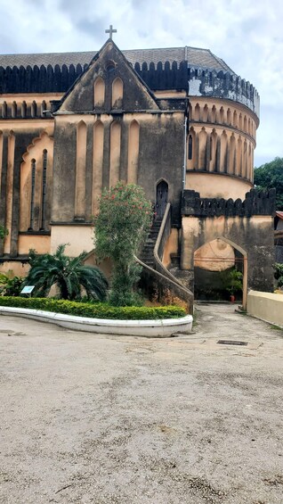 A historic church with a cross on the roof, a bell tower, and a staircase leading to the entrance. 5