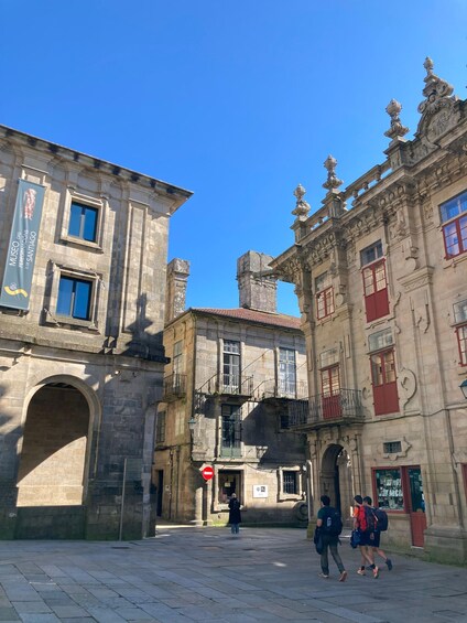 A historic building with ornate architecture, a clear blue sky, and a paved square. 4