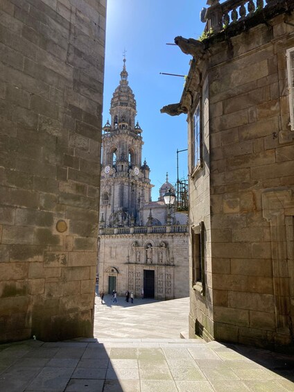 A historic cathedral with a bell tower, surrounded by stone buildings. 5