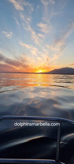 A sunset over a body of water with a mountain in the background. 5