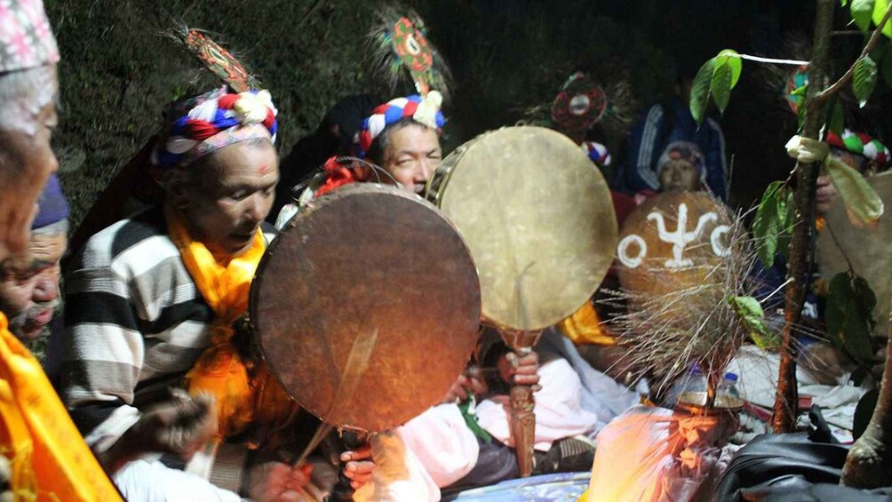 A group of people holding large drums, wearing colorful headdresses, and participating in a cultural event. 5