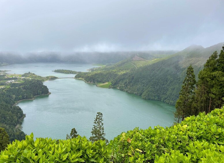 A lake surrounded by lush green hills and dense forests. 2