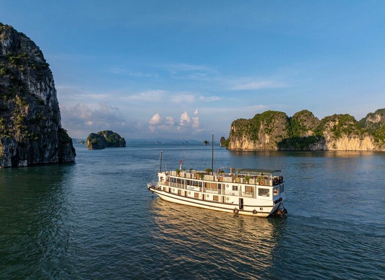 A boat on calm waters with rocky cliffs and small islands in the background. 2