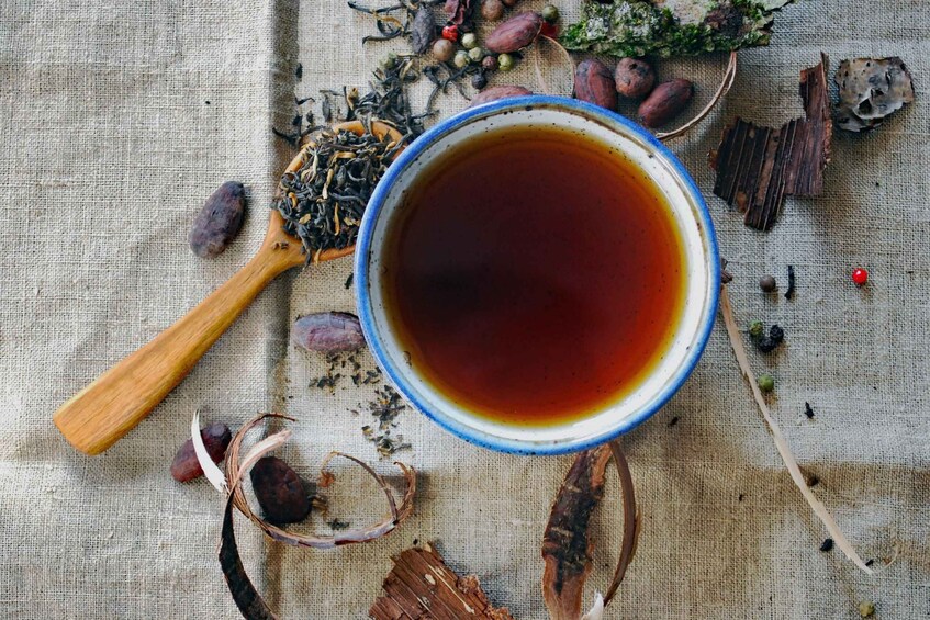 A blue and white cup of tea with a wooden spoon on a burlap cloth. 5