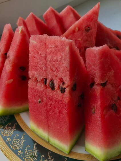 A plate of watermelon slices with seeds. 3