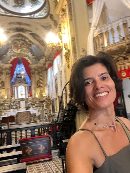 A woman in a church with ornate architecture and a stained glass window. 3
