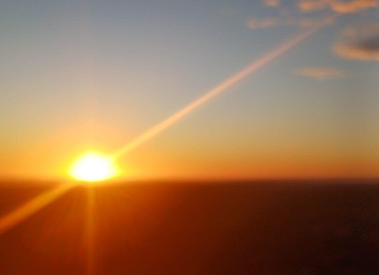 A sunset with the sun low on the horizon, casting a warm glow across the sky. 2