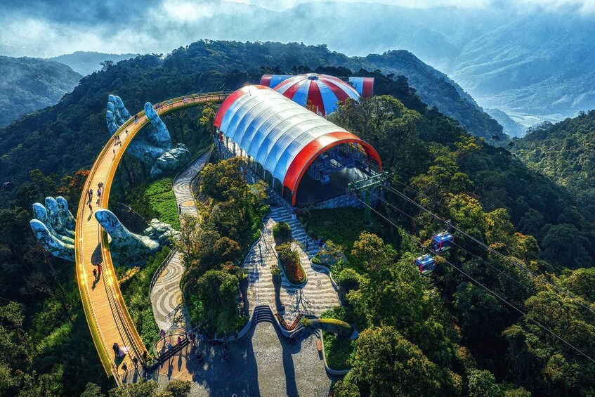 A cable car system in a mountainous area with a large, colorful, striped structure. 1
