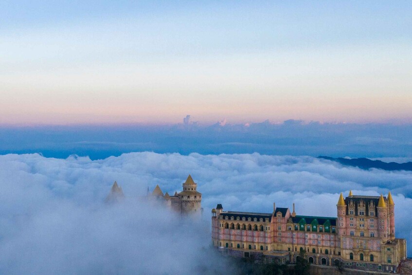 A castle-like building surrounded by clouds at sunrise. 5