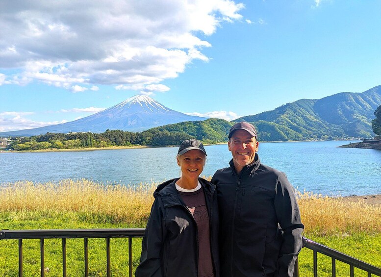Two people standing by a lake with a mountain in the background. 1