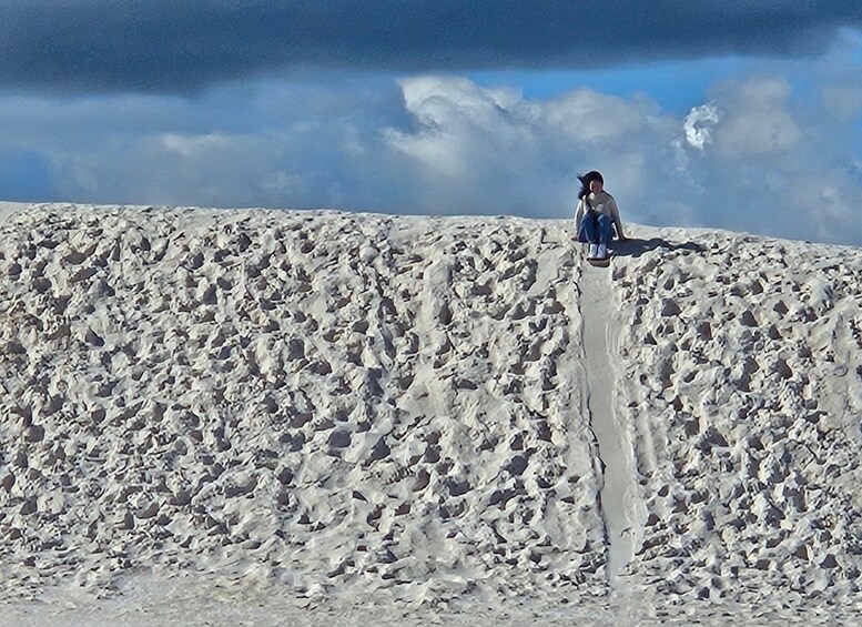 A person standing on a snow-covered slope with a clear sky in the background. 3