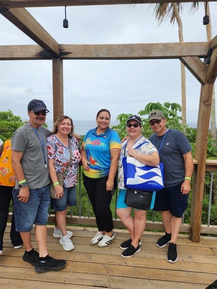 A group of people standing on a wooden deck with a wooden structure overhead. 3