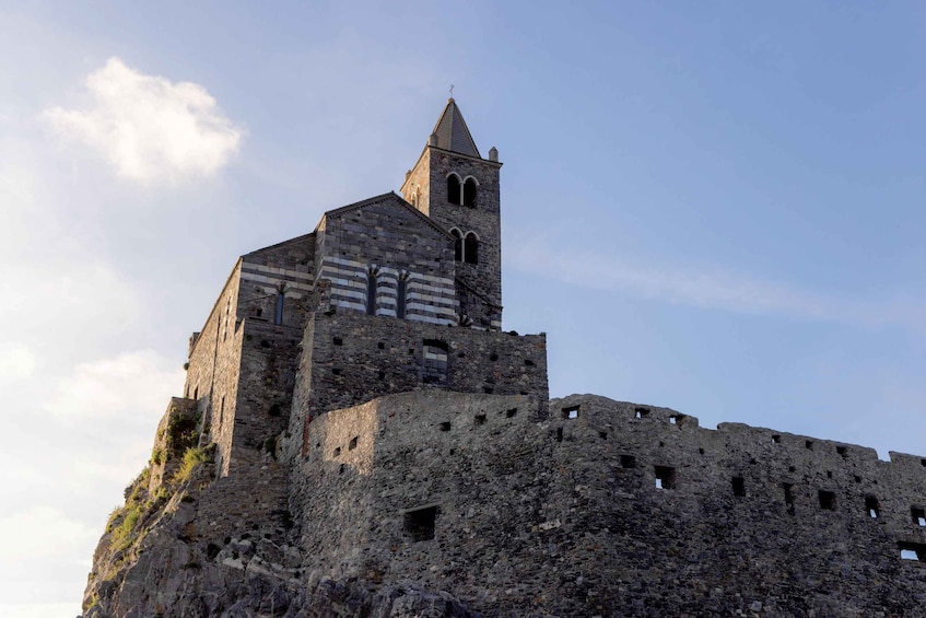 A historic stone castle with a prominent tower and crenellations. 2