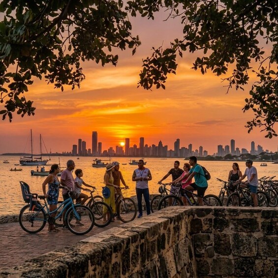 A sunset over a city skyline with people and bicycles by the waterfront. 1